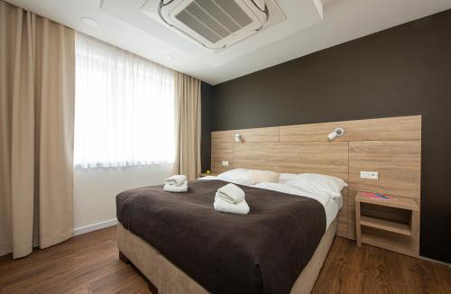 卡鲁扎Residence Šírava ***的一间卧室配有一张大床和两条毛巾