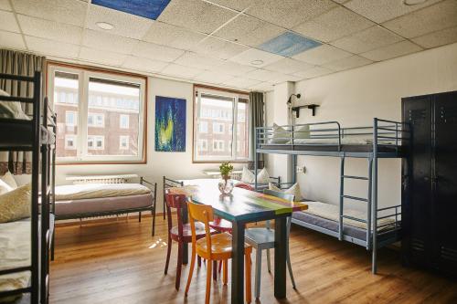 明斯特Sleep Station Hostel的客房设有双层床和桌椅。