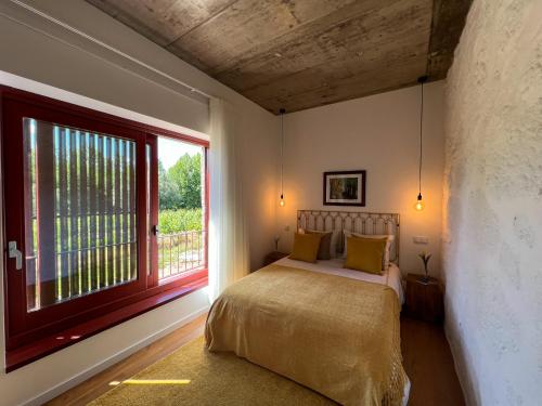 布拉加Quinta de Chousas - Braga - Agroturismo的一间卧室设有一张床和一个大窗户