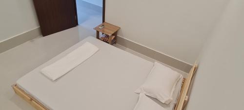 芹苴Grandma House的客房设有一张白色的床和木制盒子