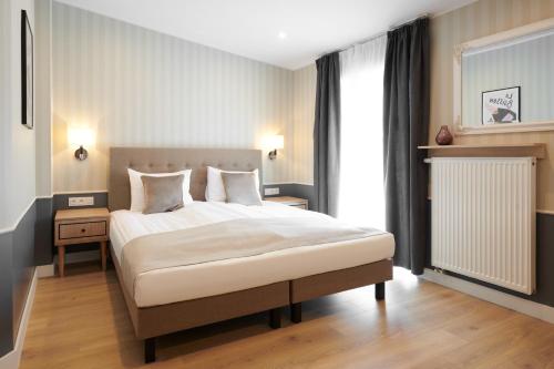 波兹南AR Apartamenty的卧室配有一张带白色床单和枕头的大床。