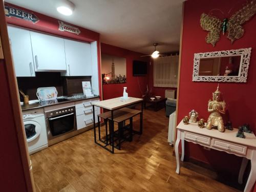 Collado MedianoApartahotel Rural CollaRubio Luxury的一间厨房,里面设有红色的墙壁和一张小桌子