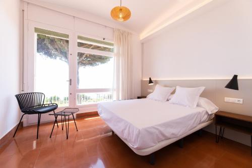 马塔罗Catalunya Casas Seafront bliss for 16 people 40km to Barcelona!的卧室配有白色的床、书桌和椅子