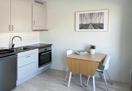 马尔默Hyllie Appartement - New Construction的厨房配有木桌和水槽。