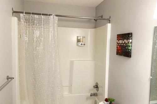 萨斯卡通Exquisite Cozy Suite/full amenities in Kensington的带浴缸的白色淋浴帘