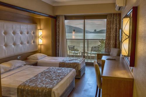 马尔马里斯Pasa Beach Hotel的酒店客房设有两张床和一个阳台。