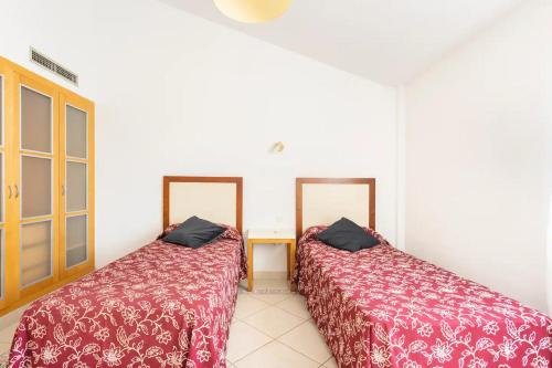 圣米格尔德阿沃纳Villa La Orotava的两张睡床彼此相邻,位于一个房间里