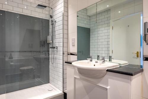 巴拉皇家白狮酒店的白色的浴室设有水槽和淋浴。