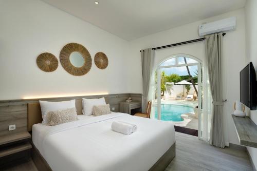 坎古Kemari Studio的一间带白色床的卧室和一个游泳池