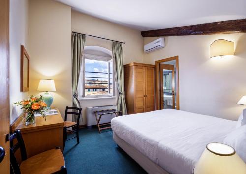 佛罗伦萨波提瑟利酒店的配有一张床、一张书桌和一扇窗户的酒店客房