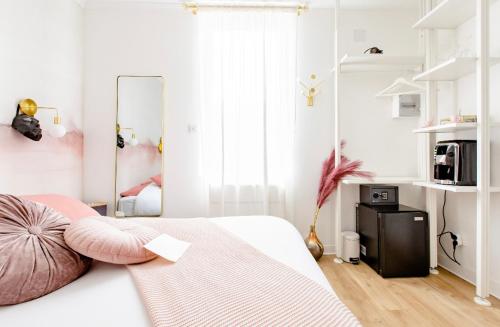 维姆勒Love Room LOsmose chambre Alchimie Bed and Breakfast Wimereux的白色卧室配有带粉红色枕头的床