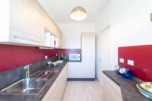阿尔盖罗Blue Vibes的一个带水槽和红色墙壁的厨房