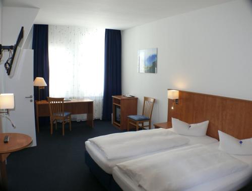 科堡加尼酒店 - 格码大宅的酒店客房设有一张大床和一张书桌。