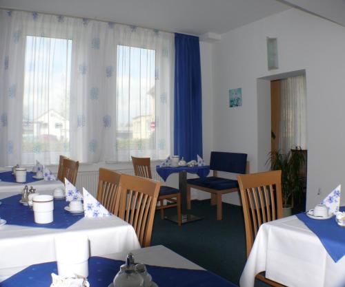 科堡加尼酒店 - 格码大宅的一间配备有蓝白色桌椅的用餐室