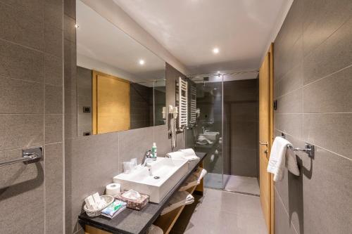 维哥迪法萨Design & Suite Hotel Ciarnadoi的一间带水槽和镜子的浴室