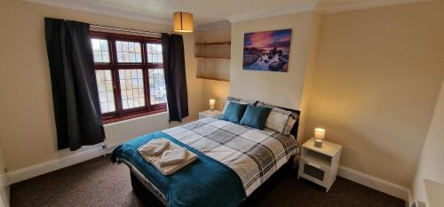 UpwellVH, 4 BR House, Upwell, Wisbech的一间卧室设有一张床和一个窗口