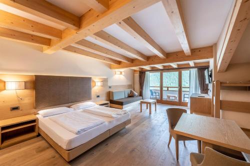 维哥迪法萨Design & Suite Hotel Ciarnadoi的一间卧室配有一张大床和一张桌子