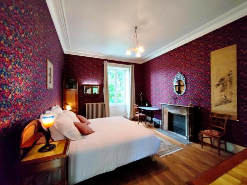 TorfouVALLÉE 1900的一间卧室设有一张大床和一个壁炉