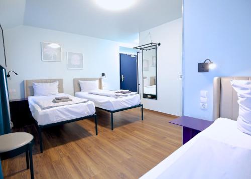慕尼黑Das Schreder Hotel的一间医院间,配有两张床和镜子