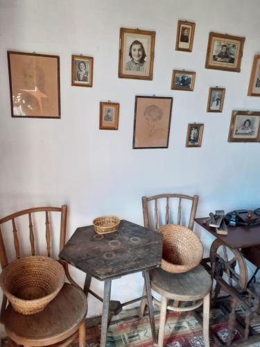 Vincellér Vendégház的配有桌椅和墙上照片的房间
