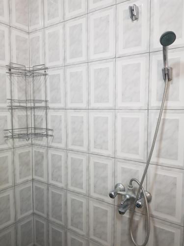 卢萨卡Kasuda House - Rent the entire house的浴室设有白色瓷砖墙壁和淋浴。