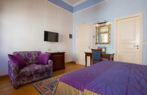 纳夫普利翁艾特马酒店 的一间卧室配有一张紫色的床、一把椅子和一张桌子