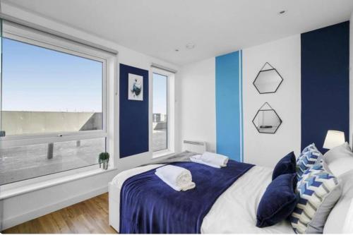 曼彻斯特Stunning 3-Bedroom Flat with Parking的蓝色和白色的卧室设有大窗户