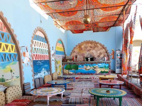 阿布辛贝Hllol Hotel Abu Simbel的墙上设有桌子和绘画的房间