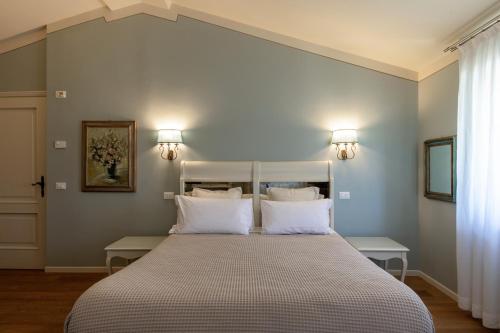 明乔河畔的瓦雷奇奥Relais Borghetto的卧室配有带白色枕头的大床