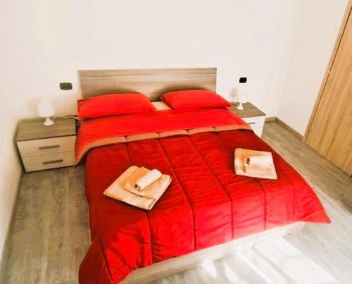 阿格拉泰布里亚恩扎LA PETITE MAISON的一间卧室配有红色的床和红色枕头
