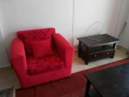 艾因苏赫纳شاليه بقرية كورنادو السخنه的客厅配有红色椅子和桌子