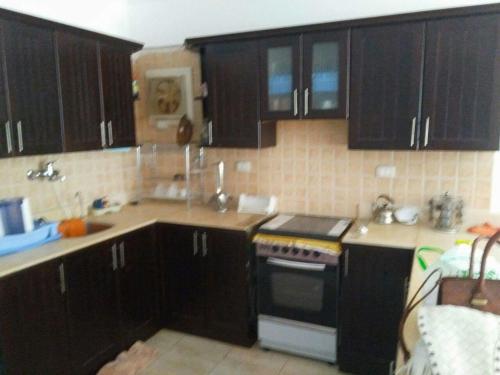 艾因苏赫纳شاليه بقرية كورنادو السخنه的厨房配有黑色橱柜和炉灶。