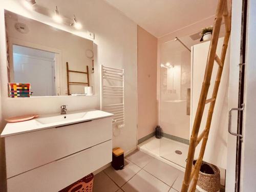 尼姆ô petit charme的白色的浴室设有水槽和淋浴。