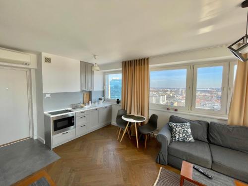 华沙ComeWa Apartments的带沙发的客厅和带窗户的厨房