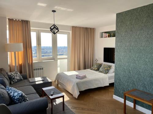 华沙ComeWa Apartments的客厅配有床和沙发