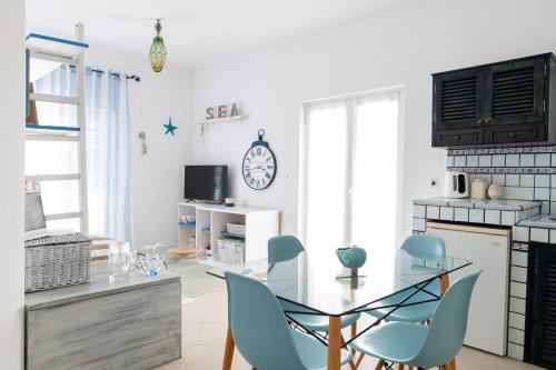 凯法洛斯Ficus Traditional Apartments的厨房配有玻璃桌和蓝色椅子