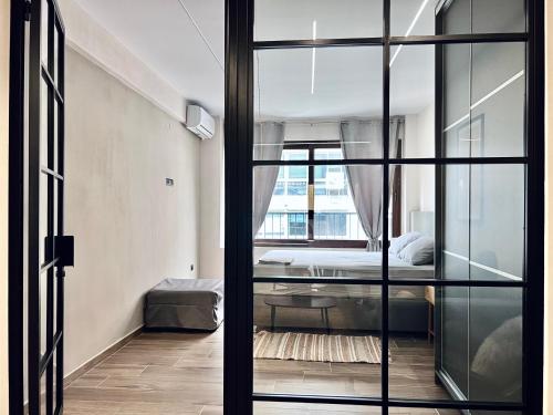 塞萨洛尼基Modiano Luxury Apartment Thessaloniki的一间卧室设有一张床和一个玻璃门