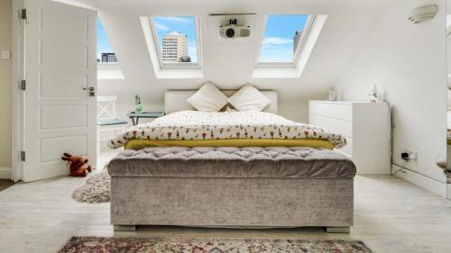 伦敦Cosy Luxurious Family Home的一间卧室设有一张床和两个窗户。