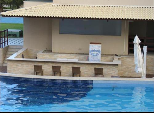嘎林海斯港Ekoara Residence - Muro Alto的一座带椅子的游泳池,位于大楼旁
