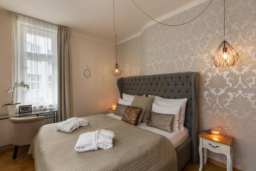 布拉格Romantic Balcony Apartment in Old Town的一间卧室配有带毛巾的床