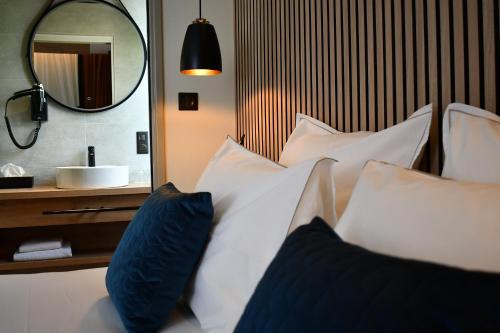 吉福蒙尚波贝尔Le Cheval Blanc - Lac du Der - Logis Hotel的一张带蓝色和白色枕头及镜子的床