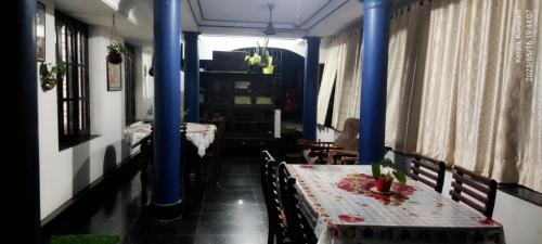 可瓦兰Annie's Villa的一间设有两张桌子和蓝色圆柱的用餐室