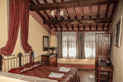 圣吉米纳诺贵奇阿迪尼农场的一间卧室配有一张床、梳妆台和窗户。