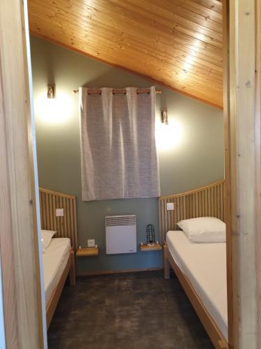 PoncinsNid Douillet的小房间设有两张床和窗户