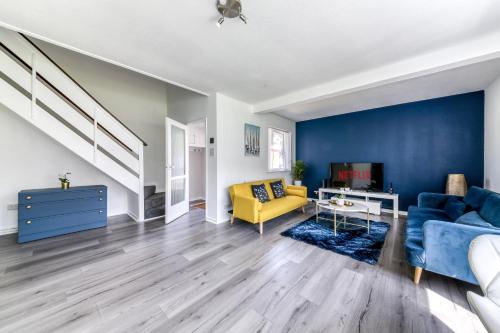 克罗伊登Contemporary 4 bedroom detached house with parking and city links的客厅拥有蓝色的墙壁和黄色的沙发