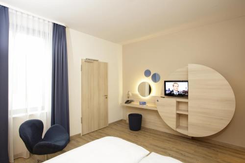 柏林柏林亚历山大广场H2酒店的一间卧室配有床和圆镜子