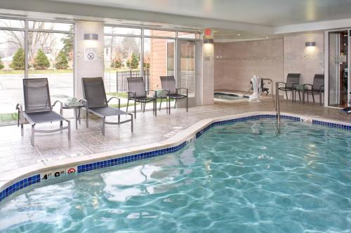 特洛伊底特律特洛伊万豪费尔菲尔德套房酒店的一座配有桌椅的酒店游泳池