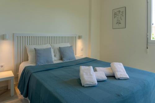 托雷德本纳贾尔邦Suite Añoreta Malaga Parking 101的一间卧室配有蓝色的床和2条毛巾