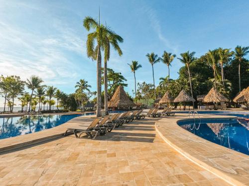 坦波巴尔赛罗坦博尔全包度假村的一个带椅子和棕榈树的度假游泳池