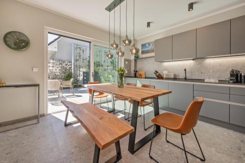 卢布明Lubminer Meerblick Apartments的厨房以及带木桌和椅子的用餐室。